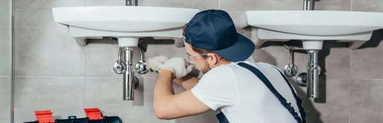 local service ads for plumbers - a plumber fixes a sink drain